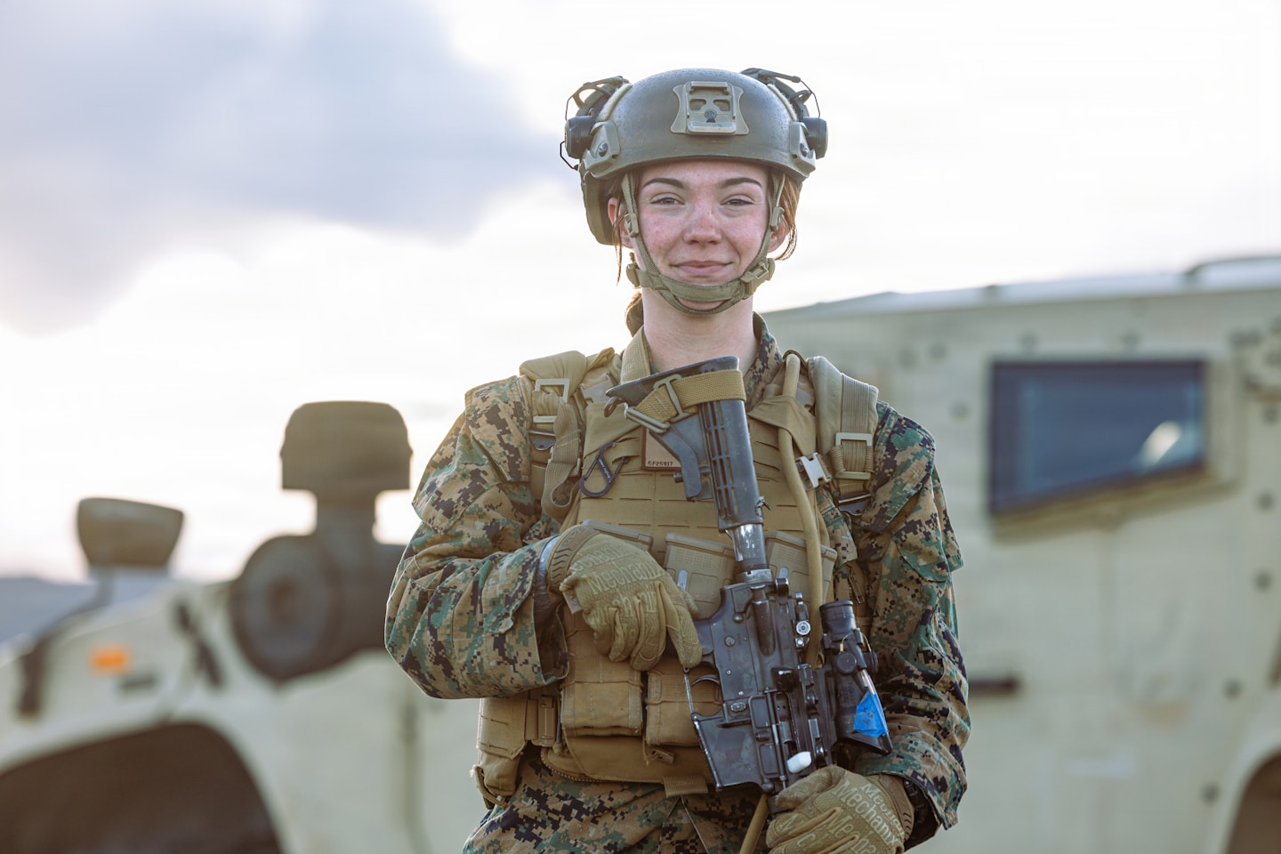 U.S. Navy Hospital Corpsman 3rd Class Cheyenne Farmer, currently assigned to 3rd Battalion, 12th Marine Littoral Regiment, 3rd Marine Division, and a native of Cincinnati, Ohio, poses for a photo in front of a Joint Light Tactical Vehicle during a High Mobility Artillery Rocket System rapid infiltration at Marine Corps Air Station Iwakuni, Japan, Dec. 3, 2025. A HIRAIN was conducted on MCAS Iwakuni to help maintain mission readiness by simulating a mock scenario of identifying a target, seizing key terrain, inserting HIMARS, destroying the target and returning back to a secure location. The Marines from Charlie Company, 11th Regiment, 1st Marine Division are currently a part of a unit deployment program with 3rd Battalion, 12th Marine Littoral Regiment, 3rd Marine Division, the UDP allows Marines to train under different commands in various ways. (U.S. Marine Corps photo by Cpl. Sarah M. Grawcock)