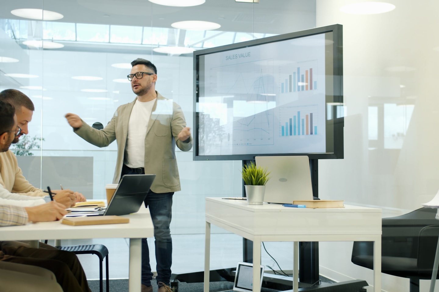 Business expert speaking about marketing in office using digital whiteboard, group of people listening and learning. Modern technology and sales concept.